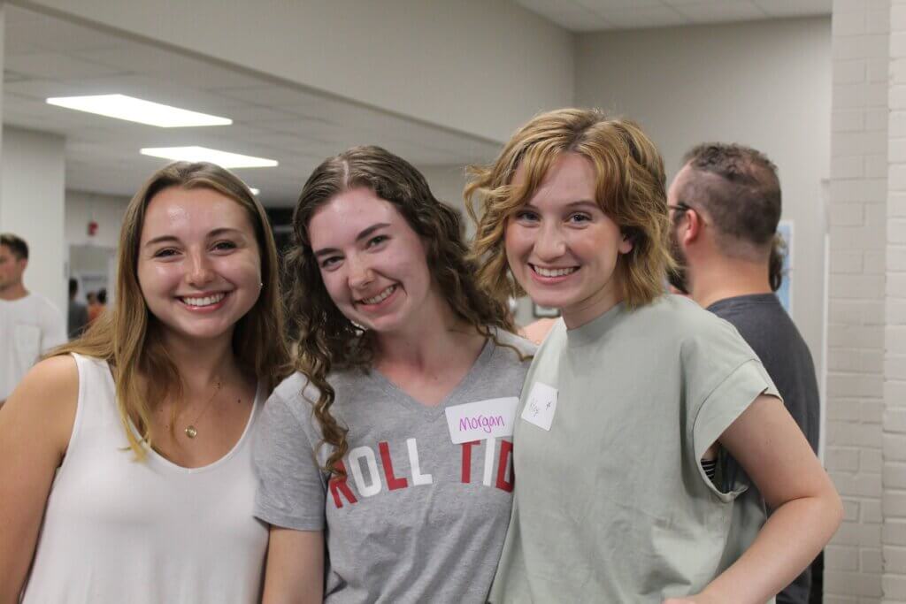 Three college girls pose for a picture inside church