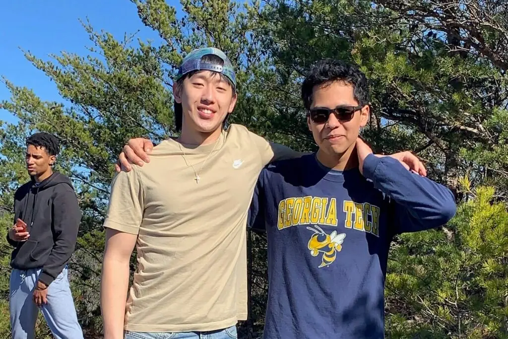 2 male international students pose for picture with arms around each other's shoulder