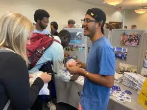 Students interact at booth at ministry fair on college campus