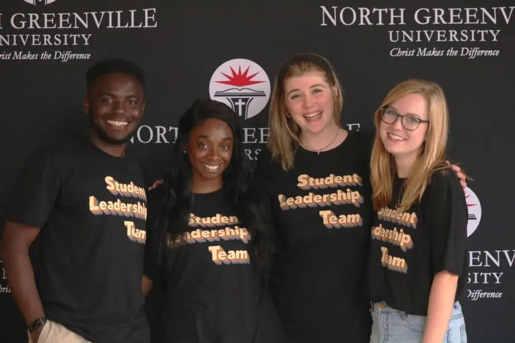 Group of student pose for picture in front of dark grey backdrop