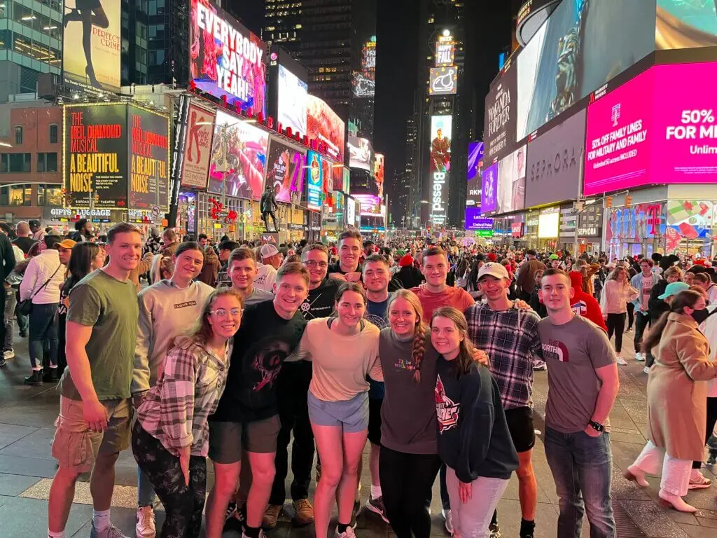 Group of college students pose for a picture in Times Square while on a mission trip