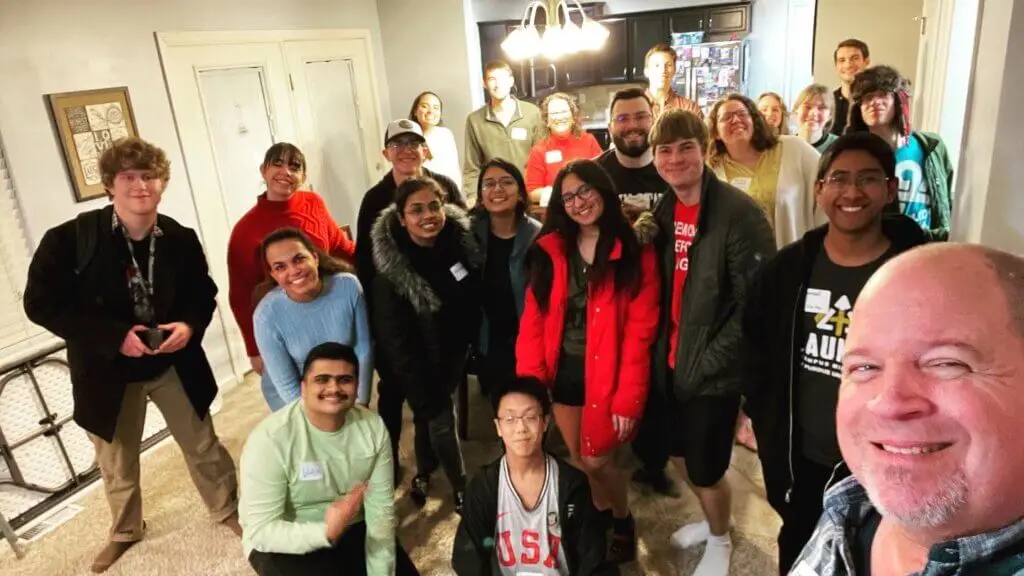 International and American students pose for a picture inside a home