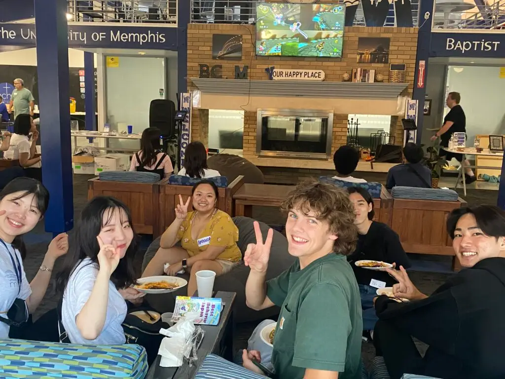 International students pose for a picture while eating dinner at the University of Memphis BCM