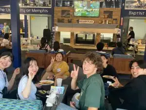 International students pose for a picture while eating dinner at the University of Memphis BCM