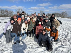 Co-ed college students pose for a group photo in the snow