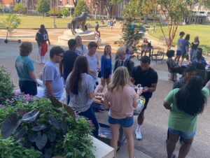 College students hand out free cookies to students on their campus' quad.