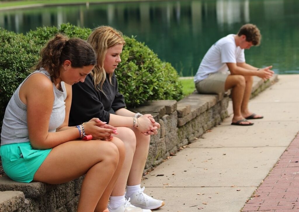 Home 3 Students sitting outside praying
