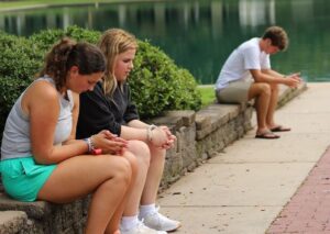 Students sitting outside praying