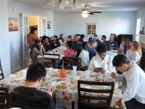 Multiple tables filled with American and international students for Thanksgiving.