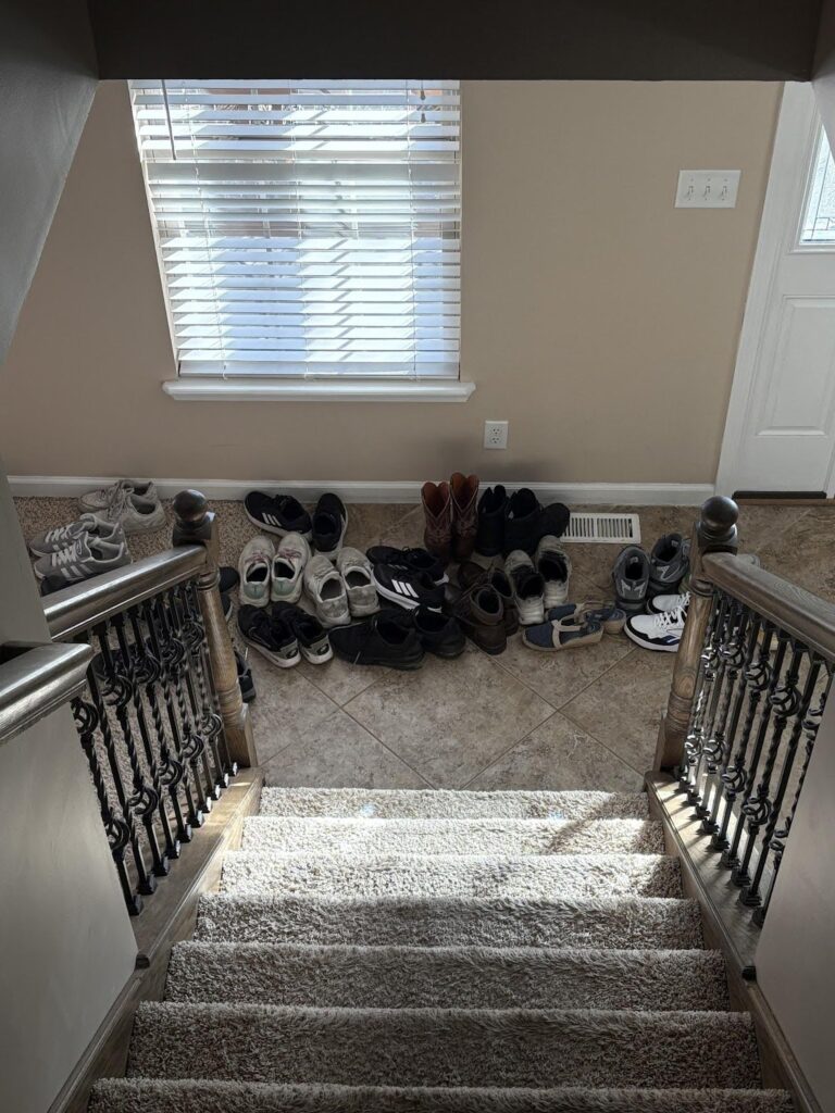 International Student Ministry: Thankful for God Moving! 2 Shoes stacked in a pile beside a door at the bottom of a staircase.